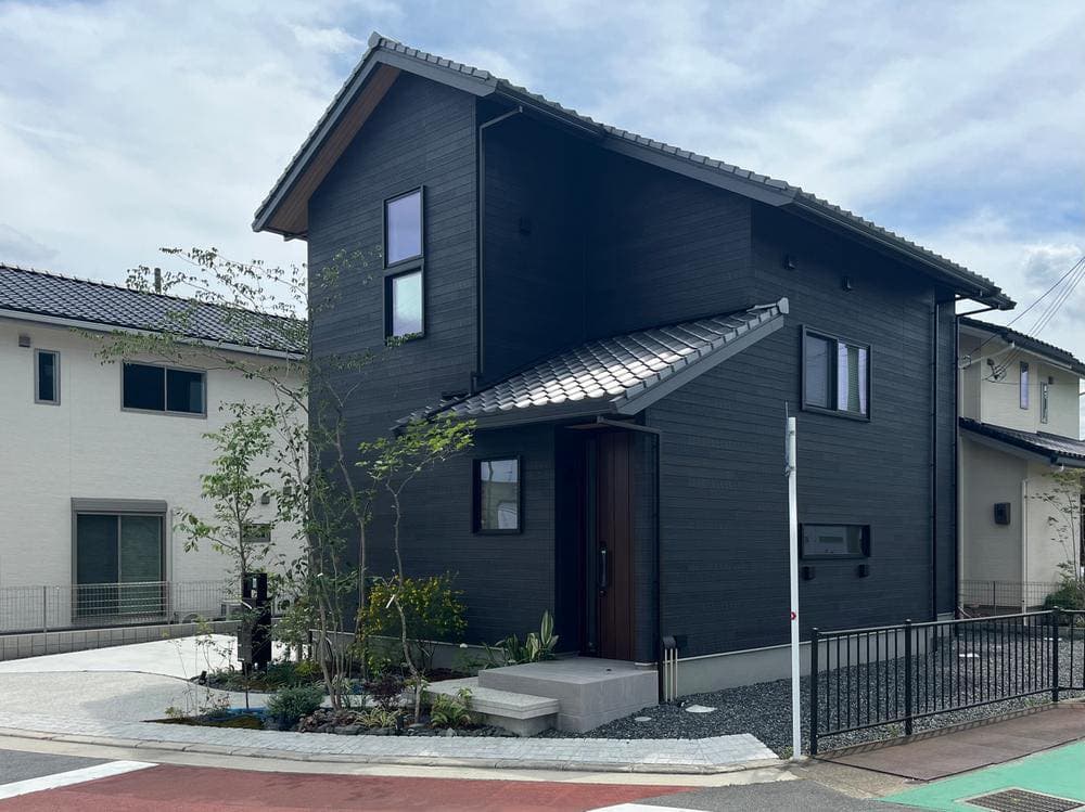 Newly built charcoal-clad two-storey house with a tiled roof — a sale listing brokered by AKI HOME in Osaka